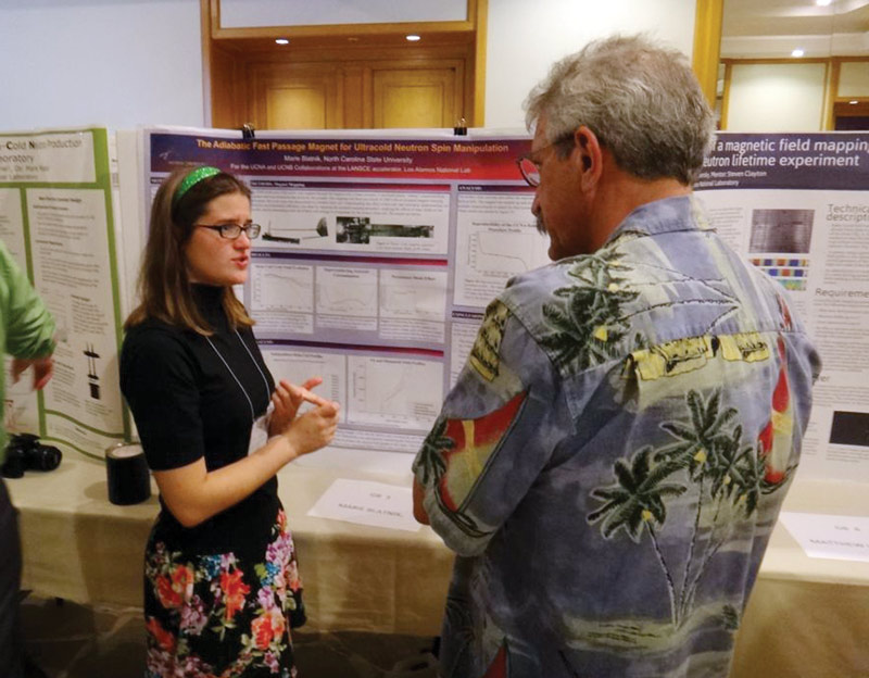 The author discusses her research on neutrons at a poster session. 