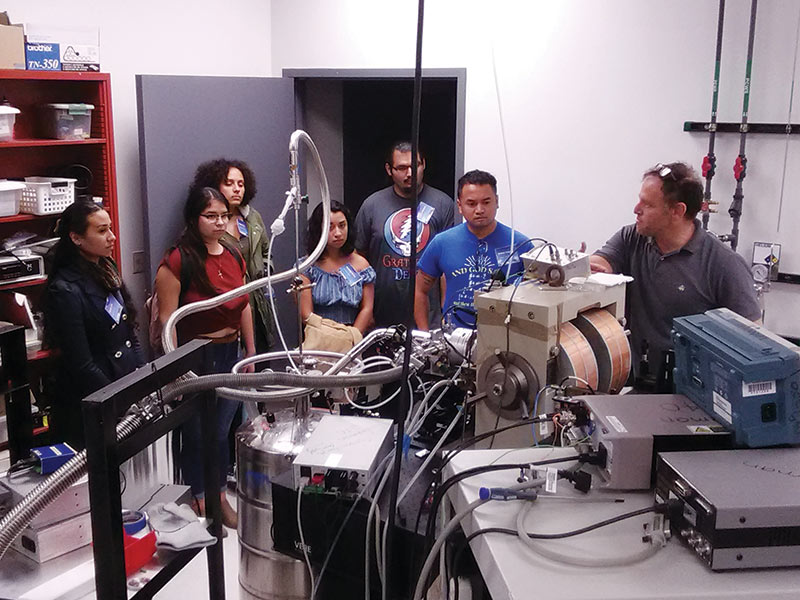 Cal-Bridge scholars tour a physics lab during orientation at the University of California, Santa Cruz.