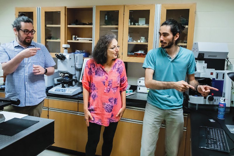 Physics professor Mariana Sendova (center), SPS president Matt Mancini (left), and treasurer Alex Sturzu (right) work together on the CRAIC microspectrophotometer and discuss the analysis needed on newly received glass samples. Photos courtesy of New College of Florida. 