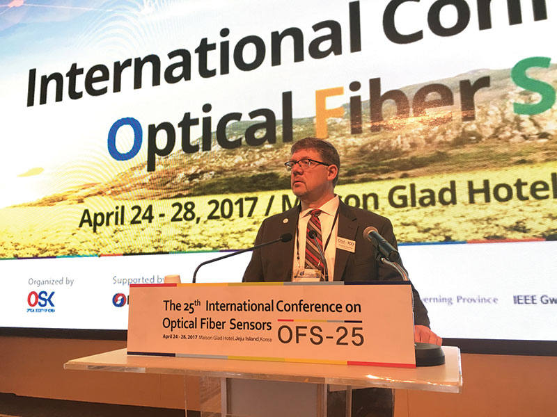 Quarles speaks to attendees on behalf of Optica (formerly OSA) during the 25th International Conference on Optical Fiber Sensors, held in 2017 on Jeju Island in South Korea.