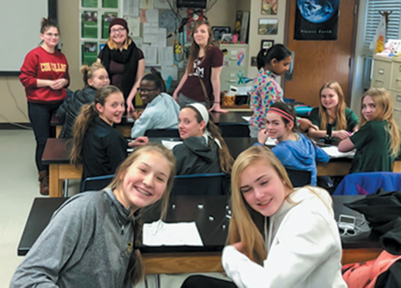 Mentors Sam Collins, Amy Houle, and Megan Houle take a break from talking about careers in STEM to pose for a picture with middle school participants. Photo courtesy of the Coe College SPS chapter.
