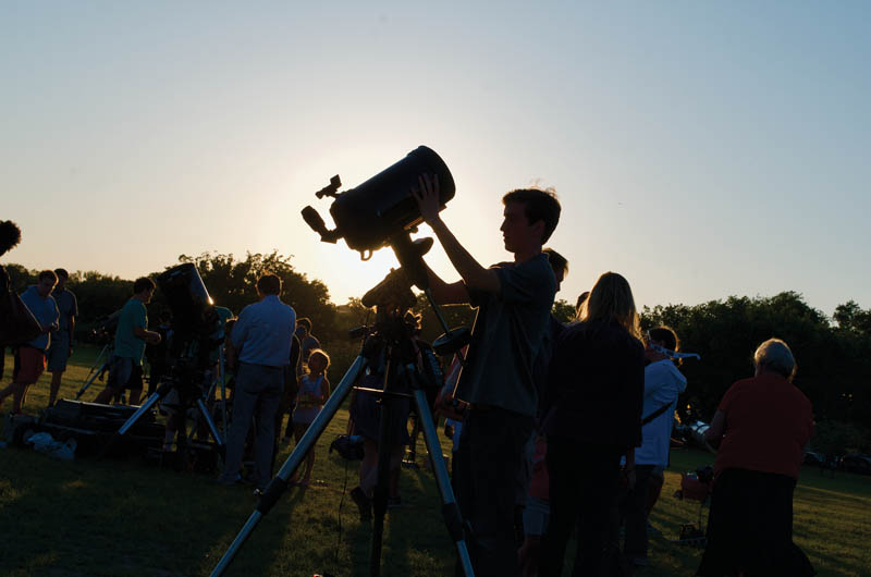 Volunteer at Astronomy on the National Mall in Washington, DC prepares telescope for participant observing during annual outreach event.