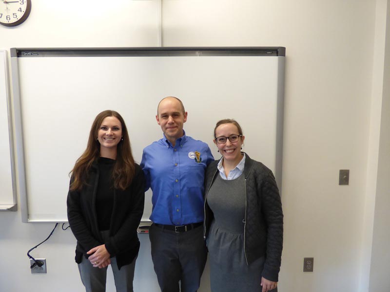 Wren Gregory (L) and Ashlyn Rickard (R) told students what graduate school is really like during their workshop, and posed here with SPS Director Brad Conrad. Photo by Michael Ruiz, UNC Asheville.
