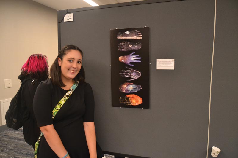 Jordan Rice, Carthage College, is pictured with her piece “We are all made of starstuff,” which won first place in the Unifying Fields (Mixed Media) category.
