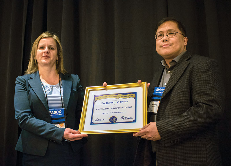  SPS Outstanding Chapter Advisor for 2018, Dr. Roberto Ramos, receives his plaque from SPS president Dr. Alina Gearba-Sell at the AAPT Winter Meeting. Photo courtesy of AAPT.