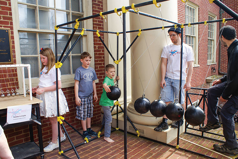Attendees enjoy the Newton’s cradle, a past SPS project, during  SciFest Sunday.