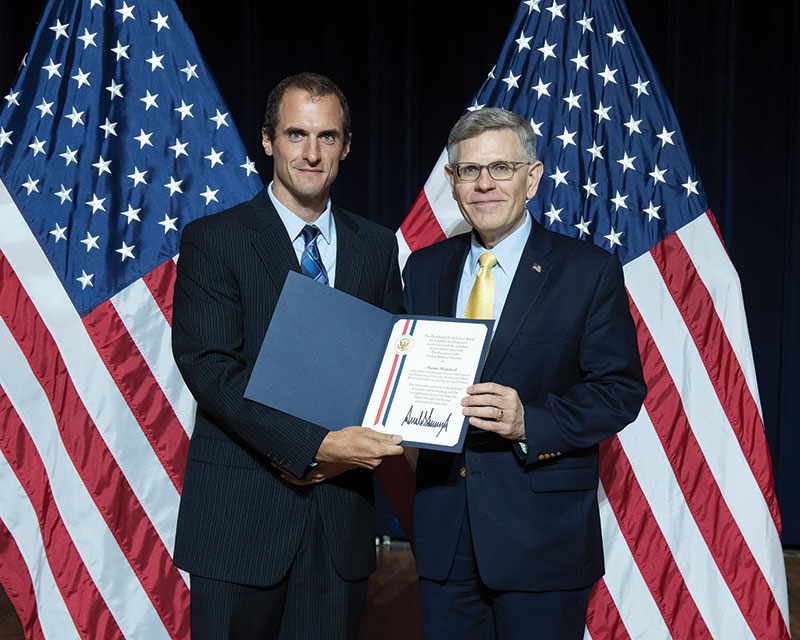 Heimbeck (left) receives the Presidential Early Career Award for Scientists and Engineers (PECASE) from Kelvin Droegemeier, Director of the United States Office of Science and Technology Policy, during a ceremony in July 2019.